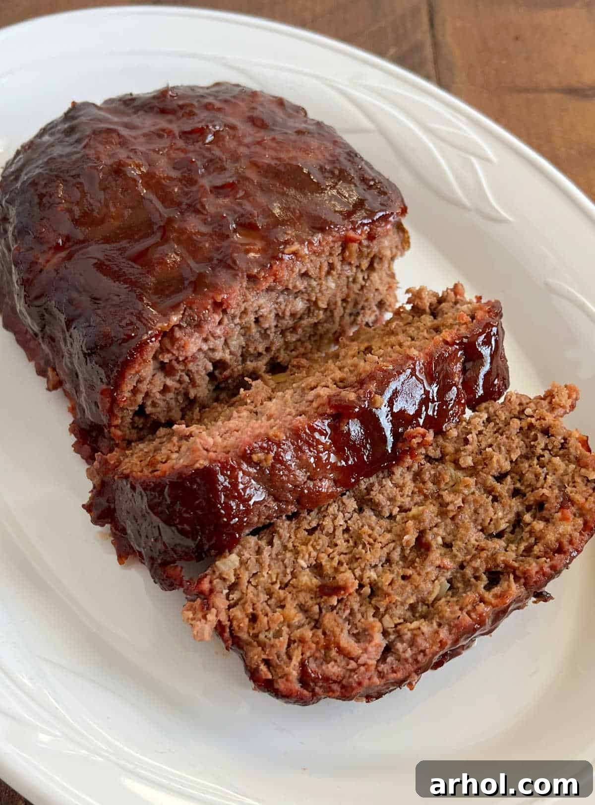 Smoky Barbecue Glazed Meatloaf 2 Sliced smoked meatloaf with BBQ glaze on a white platter, ready to serve.