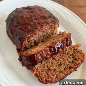 Smoked meatloaf with BBQ glaze on a white platter.