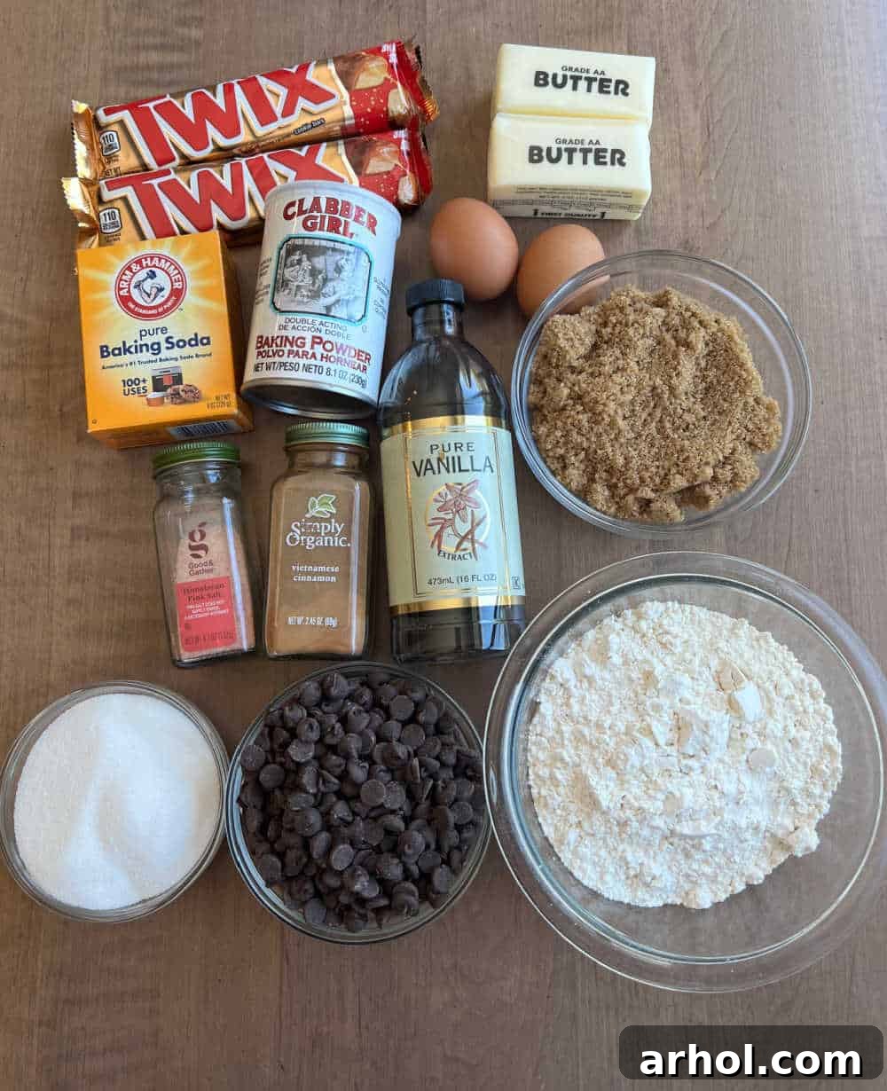 Twix candy bars and various baking ingredients laid out on a kitchen counter, ready for making Twix cookies.