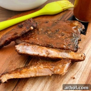 electric smoker smoked ribs with bbq sauce on cutting board.