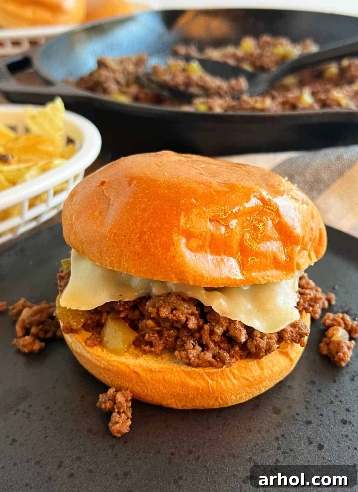 A delicious Philly Cheesesteak Sloppy Joe sandwich on a plate, showcasing melted cheese and savory ground beef filling.