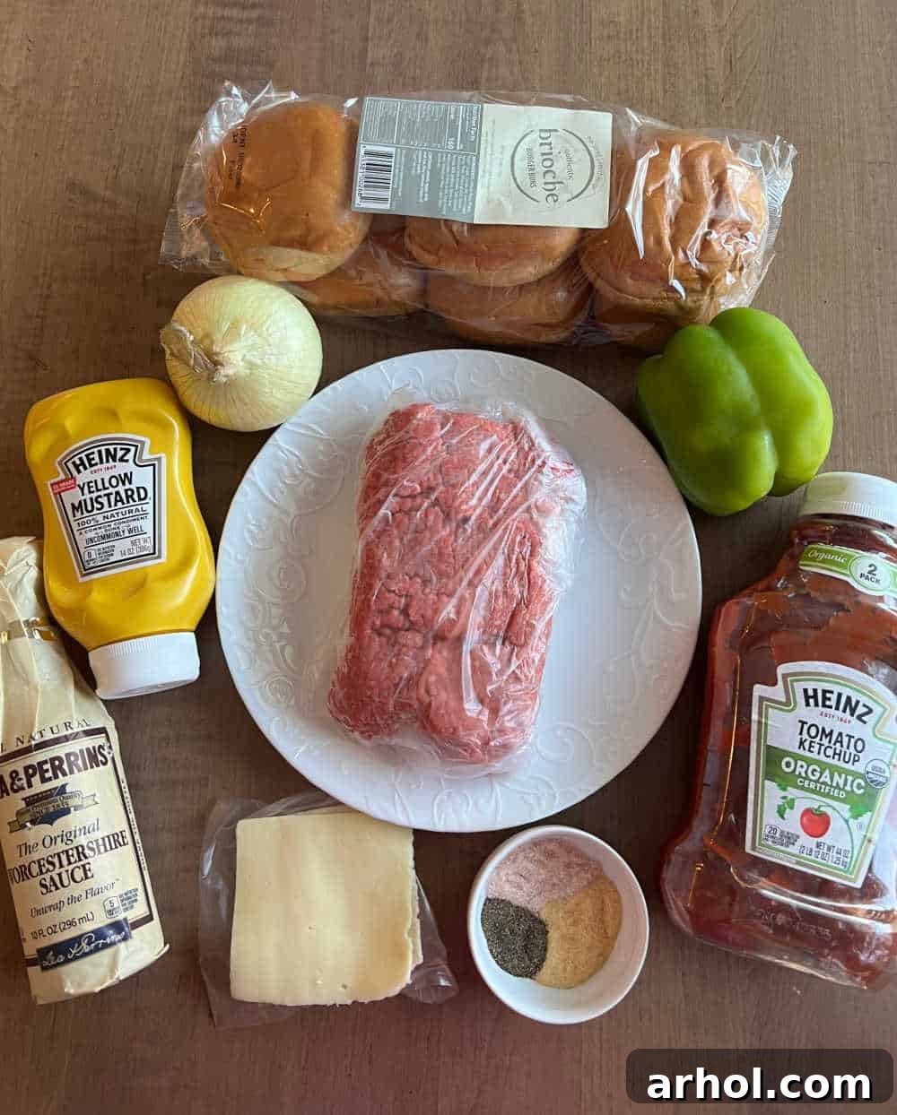 Ingredients laid out for Philly Cheesesteak Sloppy Joes: ground beef, hamburger buns, cheese slices, onions, and bell peppers.