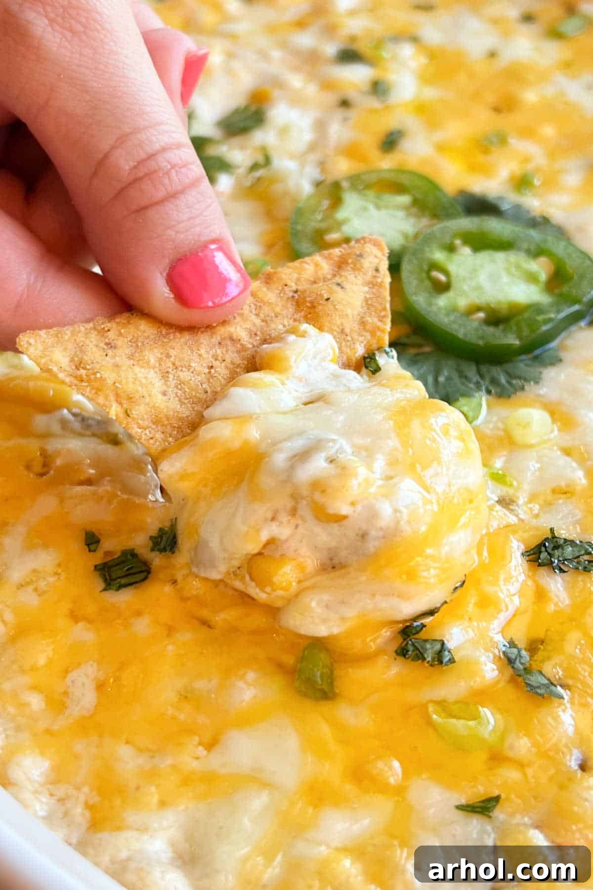 hot corn dip with cream cheese on a tortilla chip.