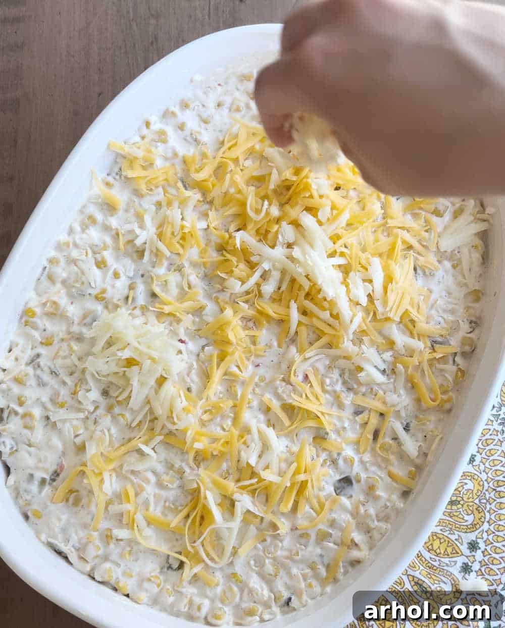 top dip with shredded cheese in casserole dish.