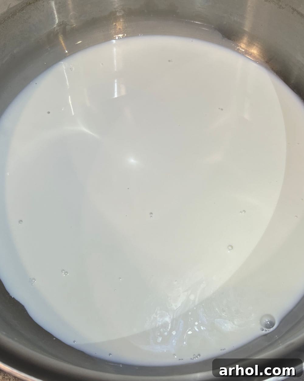 Half and half being gently warmed in a pot on the stove, preparing it for the mashed potatoes.