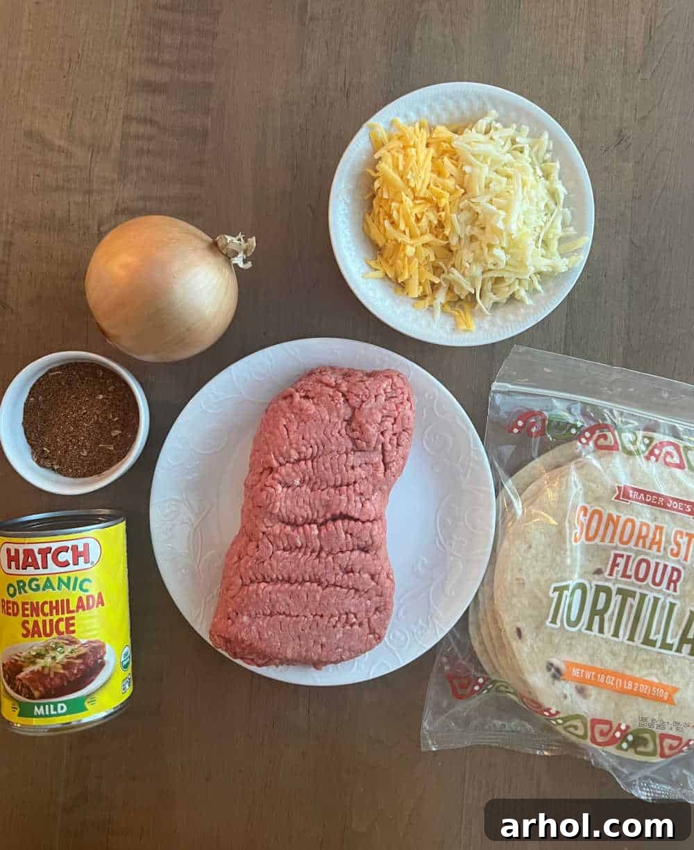 Key ingredients for easy ground beef enchiladas including ground beef, taco seasoning, red enchilada sauce, onion, shredded cheese, and flour tortillas.