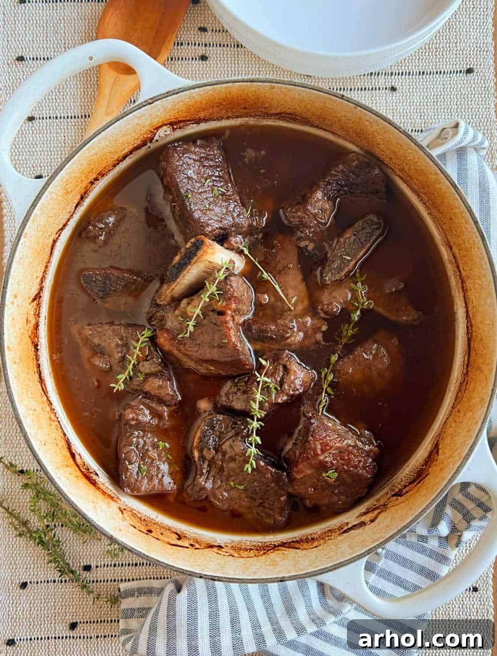 Melt-In-Your-Mouth Braised Short Ribs 7 beef short ribs in dutch oven with fresh thyme.