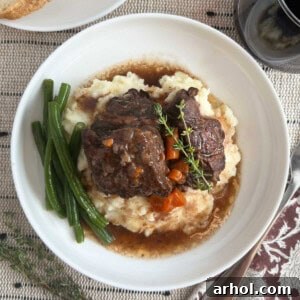 braised short ribs over mashed potatoes on plate.