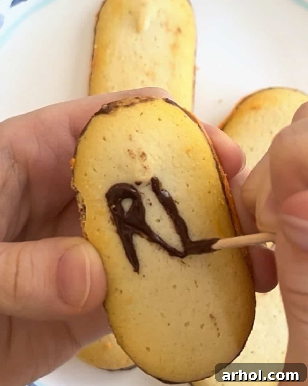Quick Spooky Dirt Cups 6 Writing 'RIP' on Milano cookies with melted chocolate, creating edible gravestones for a Halloween dessert.