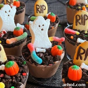 Beautifully decorated Halloween dirt cups with gummy worms, marshmallow pumpkins, and ghosts.