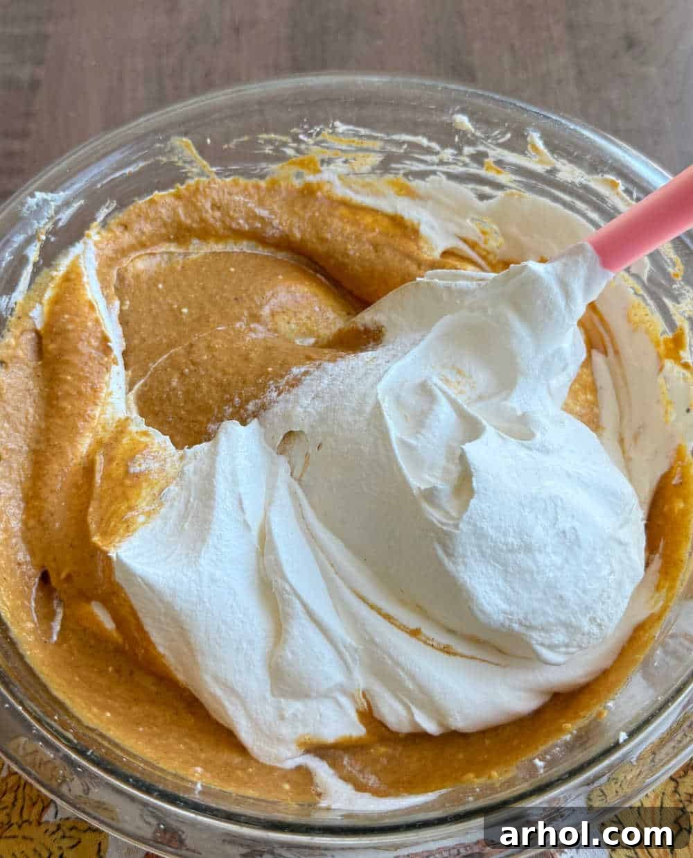 Gently folding thawed Cool Whip into the pumpkin cream cheese mixture with a rubber spatula.