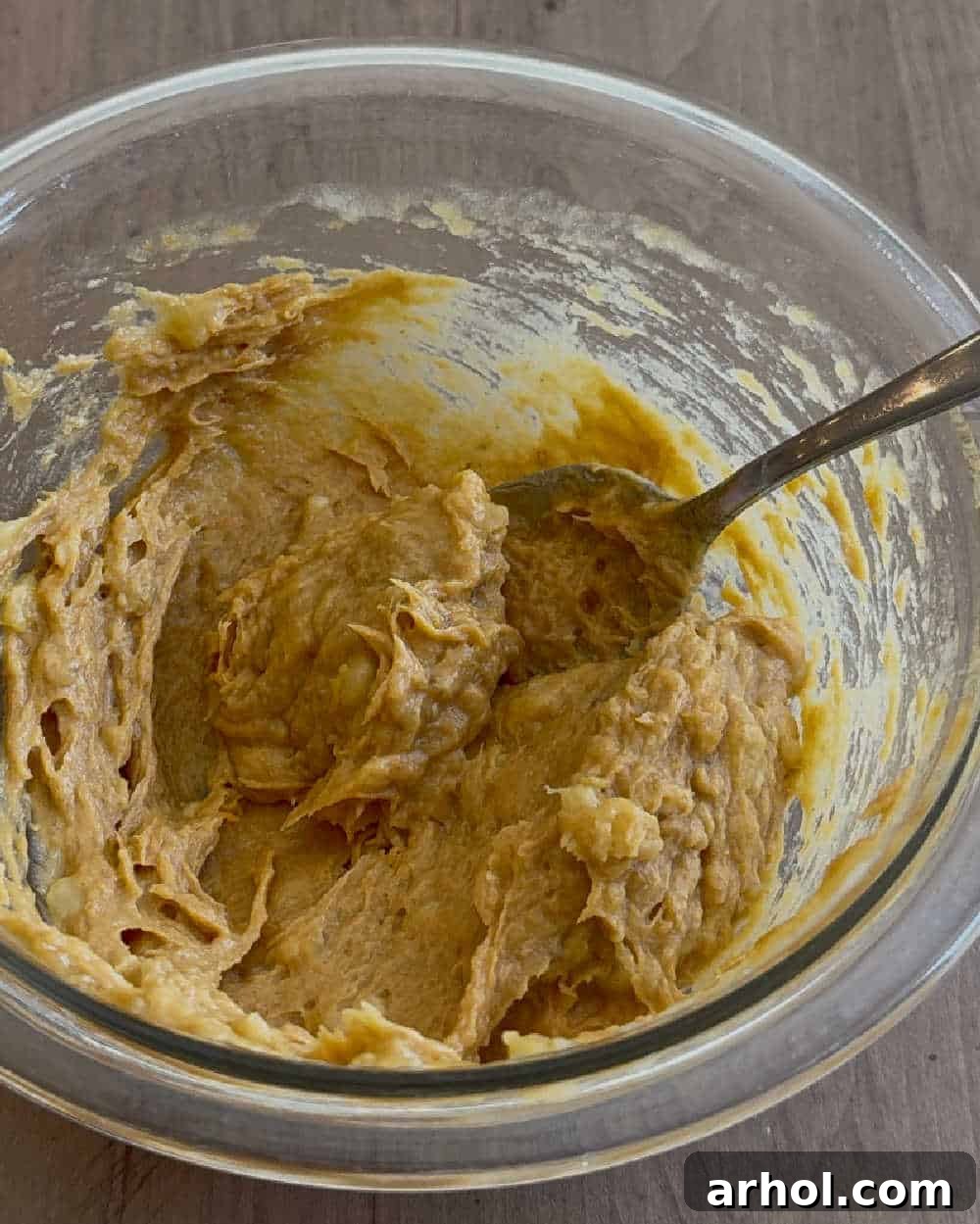 Stirring the peanut butter, banana, and pumpkin mixture together in a bowl until well blended.