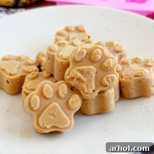 Frozen peanut butter banana dog treats shaped like paw prints on a plate.