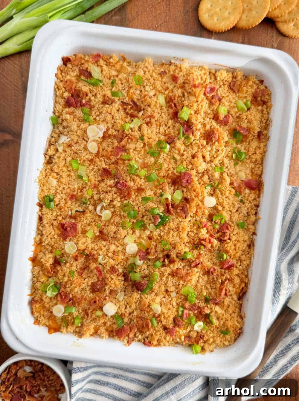 The Million Dollar Chicken Bake, beautifully golden and garnished with green onions and bacon, served on a table.