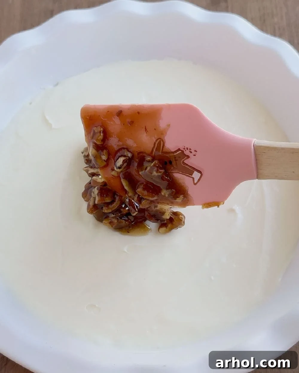 spoon topping over cream cheese.