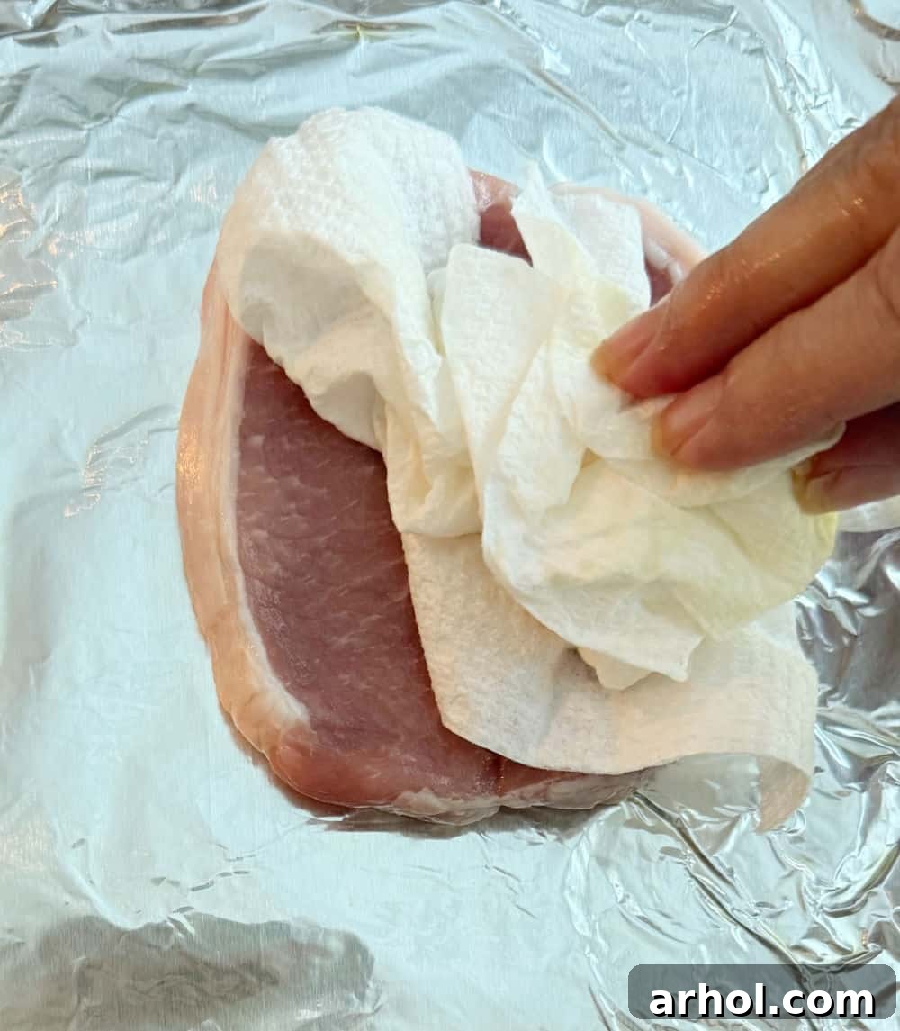 Brown Sugar Glazed Baked Pork Chops 4 Step 1: Patting raw pork chops dry with a paper towel before seasoning.
