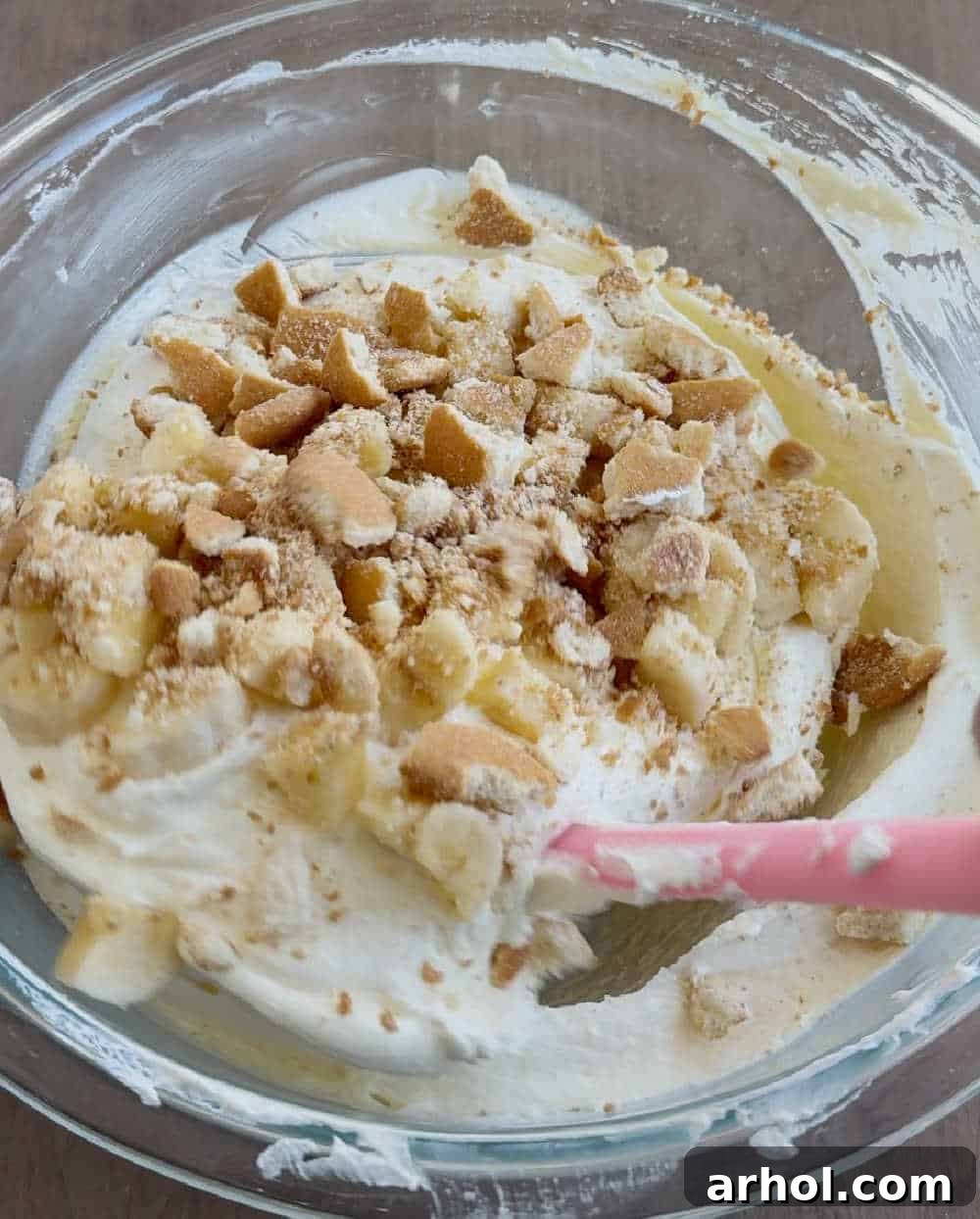 The final step shows crushed Nilla wafer cookies being stirred into the banana pudding mixture, adding texture and classic flavor.