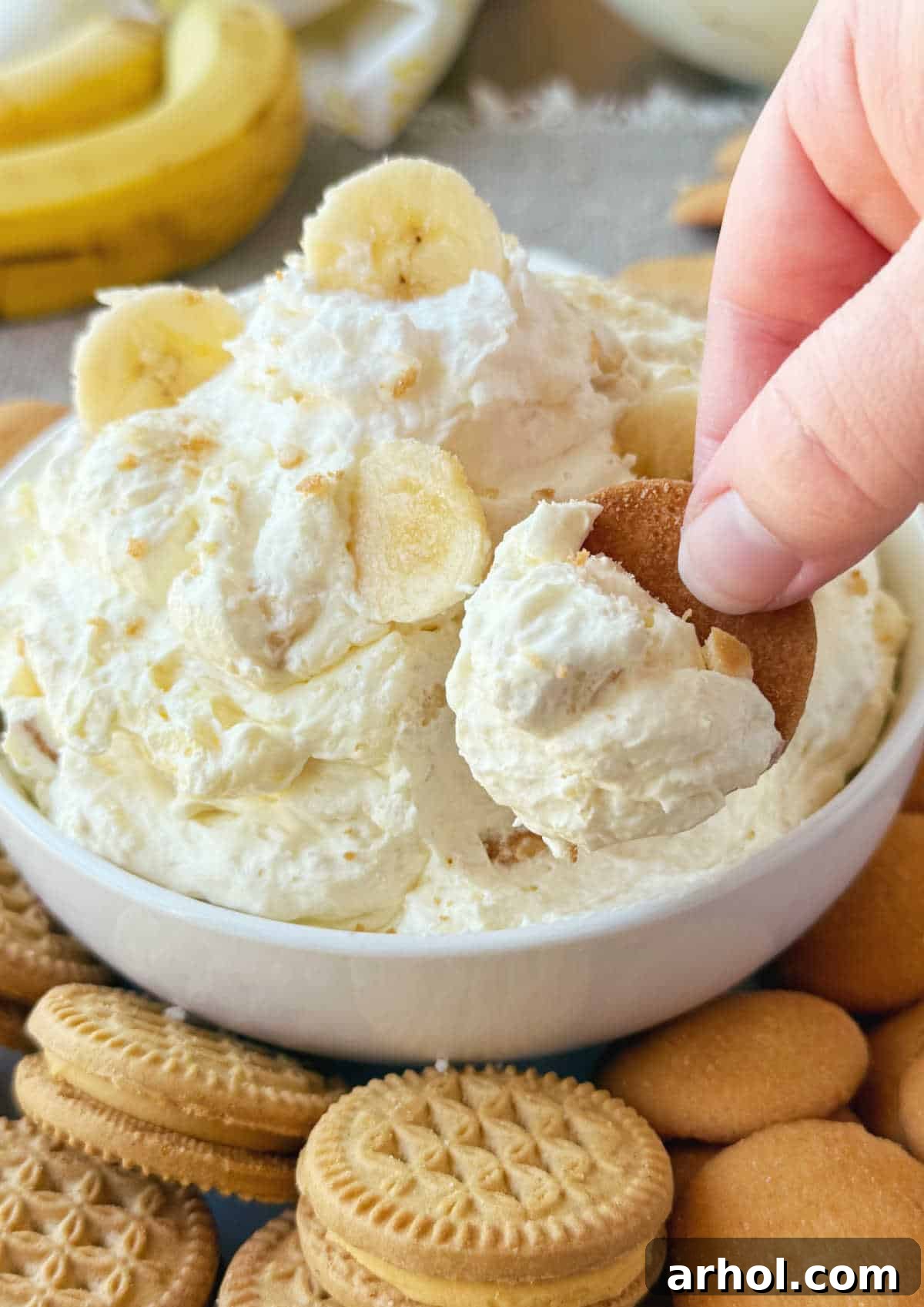 A close-up shot of the banana pudding dip artfully spread onto a Nilla wafer cookie, showcasing its creamy texture and inviting presentation.