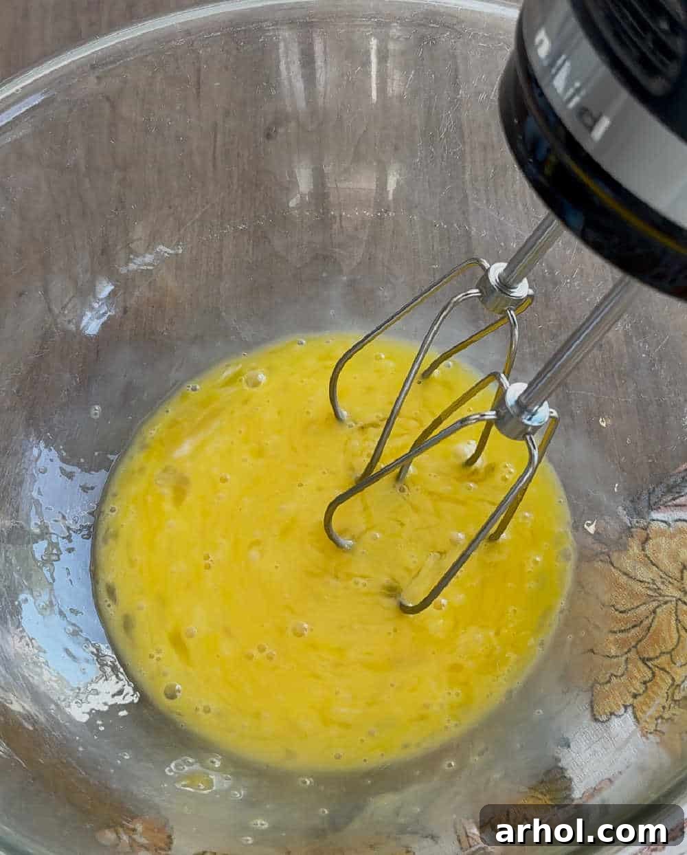 Two large eggs cracked into a mixing bowl, ready to be beaten for the pumpkin pie filling.