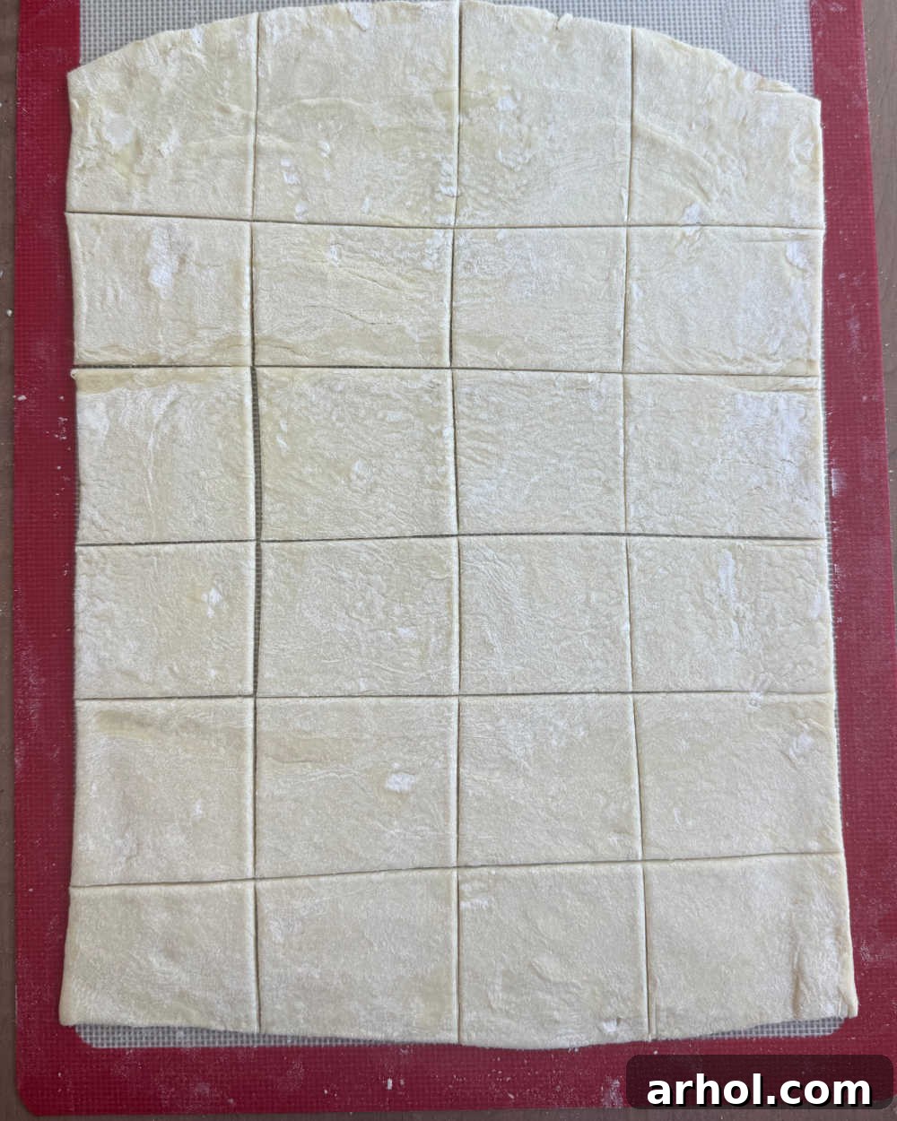 Sheet of puff pastry flattened and sliced into small squares.