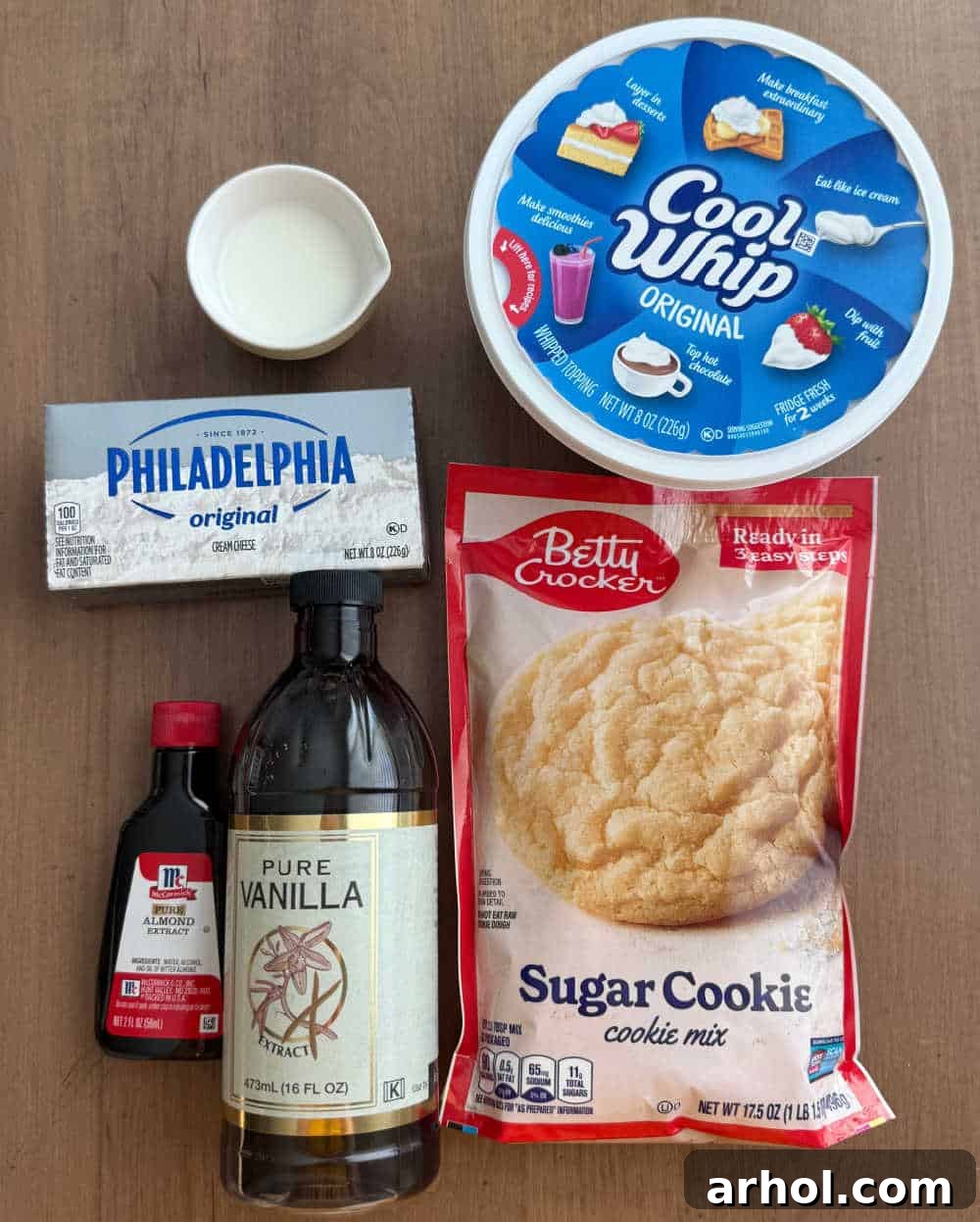 Dreamy Christmas Sugar Cookie Dip 3 sugar cookie mix, cream cheese, cool whip, milk and extracts laid out as ingredients for the dip.