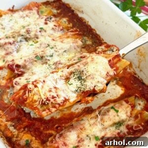 Close-up of beef and cheese manicotti on a serving spoon, showcasing the rich textures.