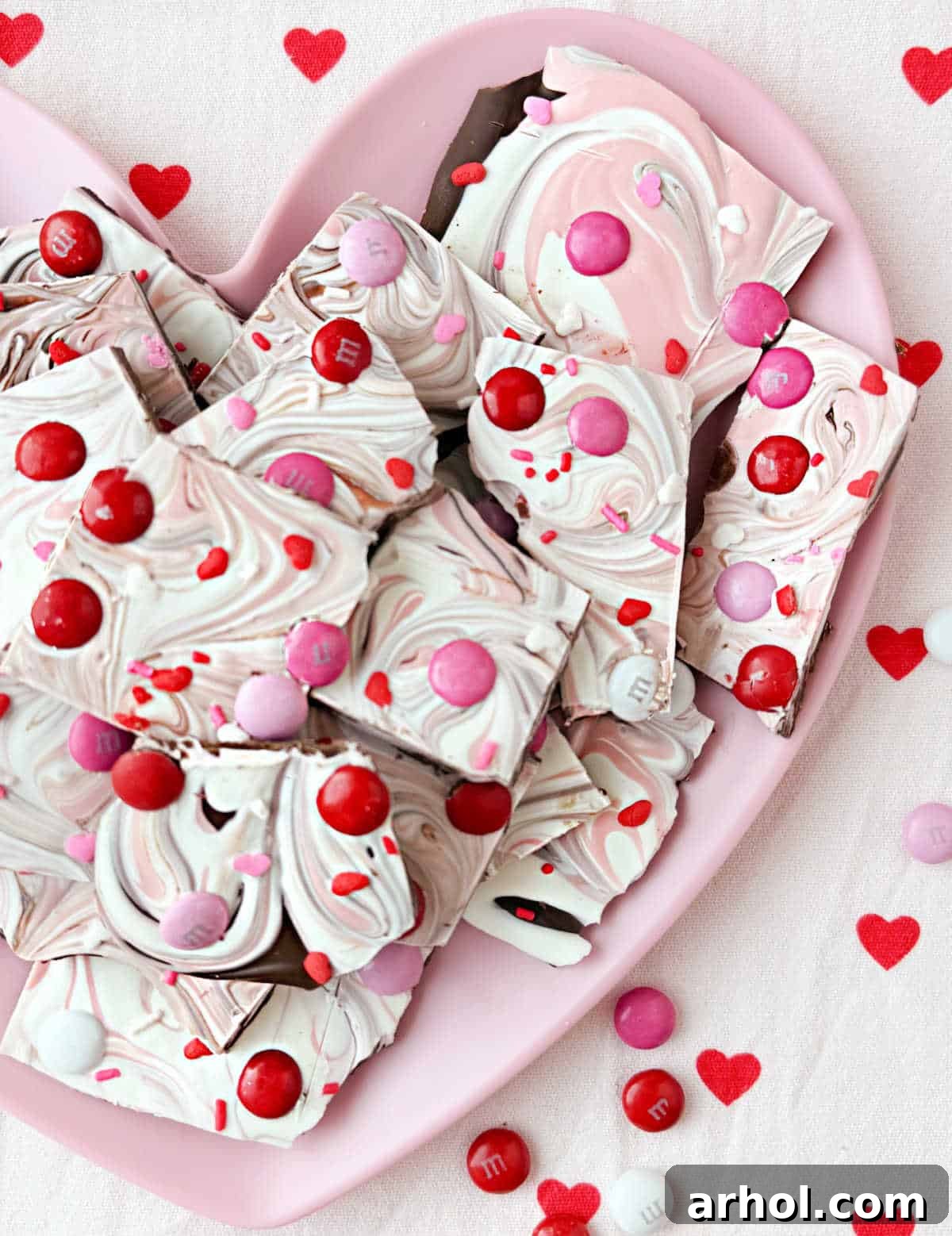 Valentine candy bark on pink heart plate, ready for serving or gifting.