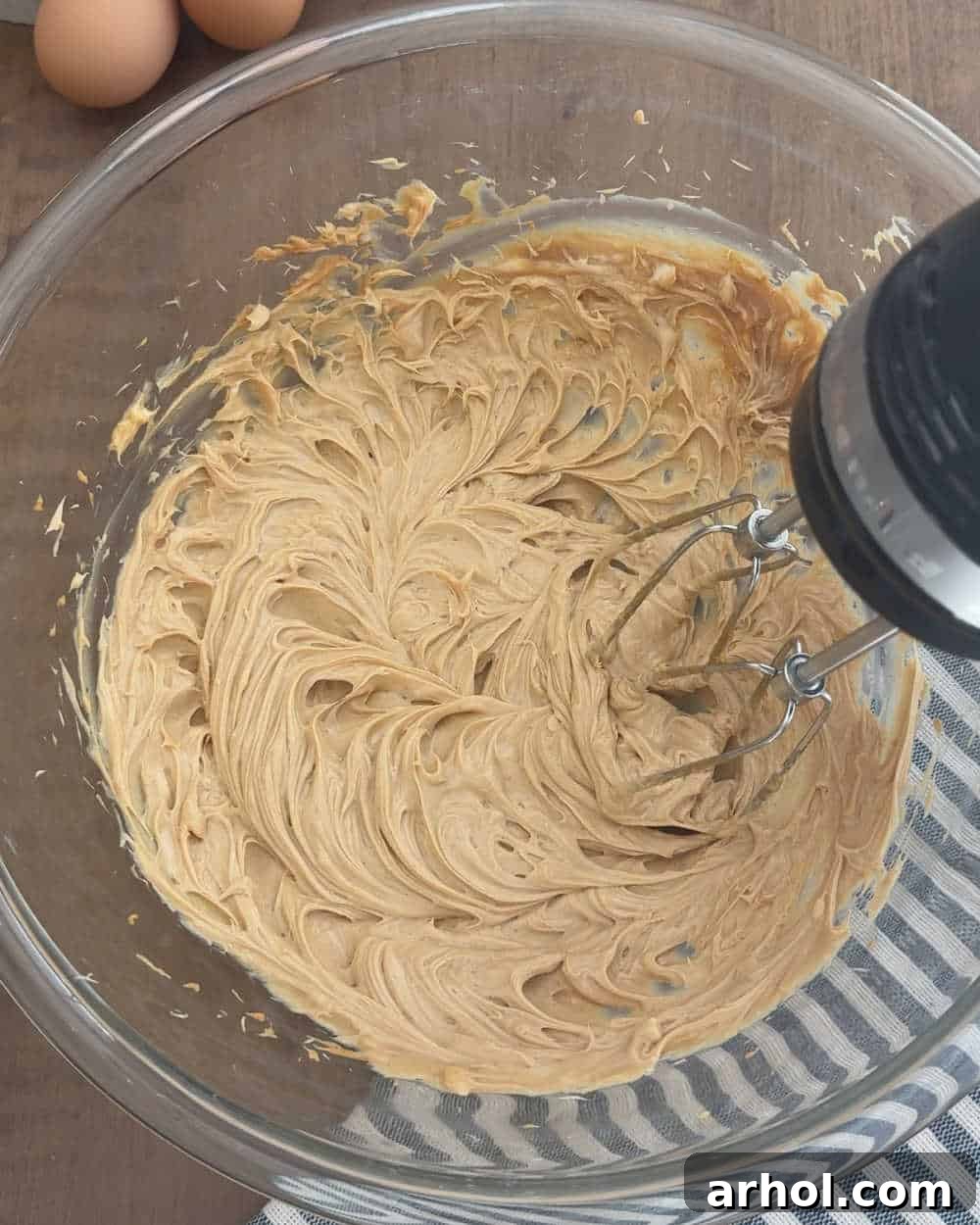 Creaming peanut butter and butter together with an electric mixer until light and fluffy.