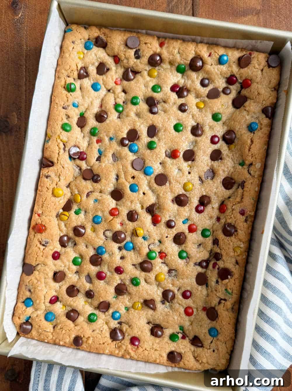 Freshly baked monster cookie bars cooling in a baking pan, ready to be sliced and enjoyed.