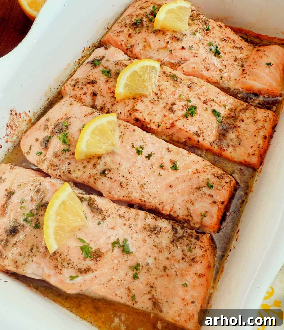 baked garlic butter salmon with lemon slices and parsley.