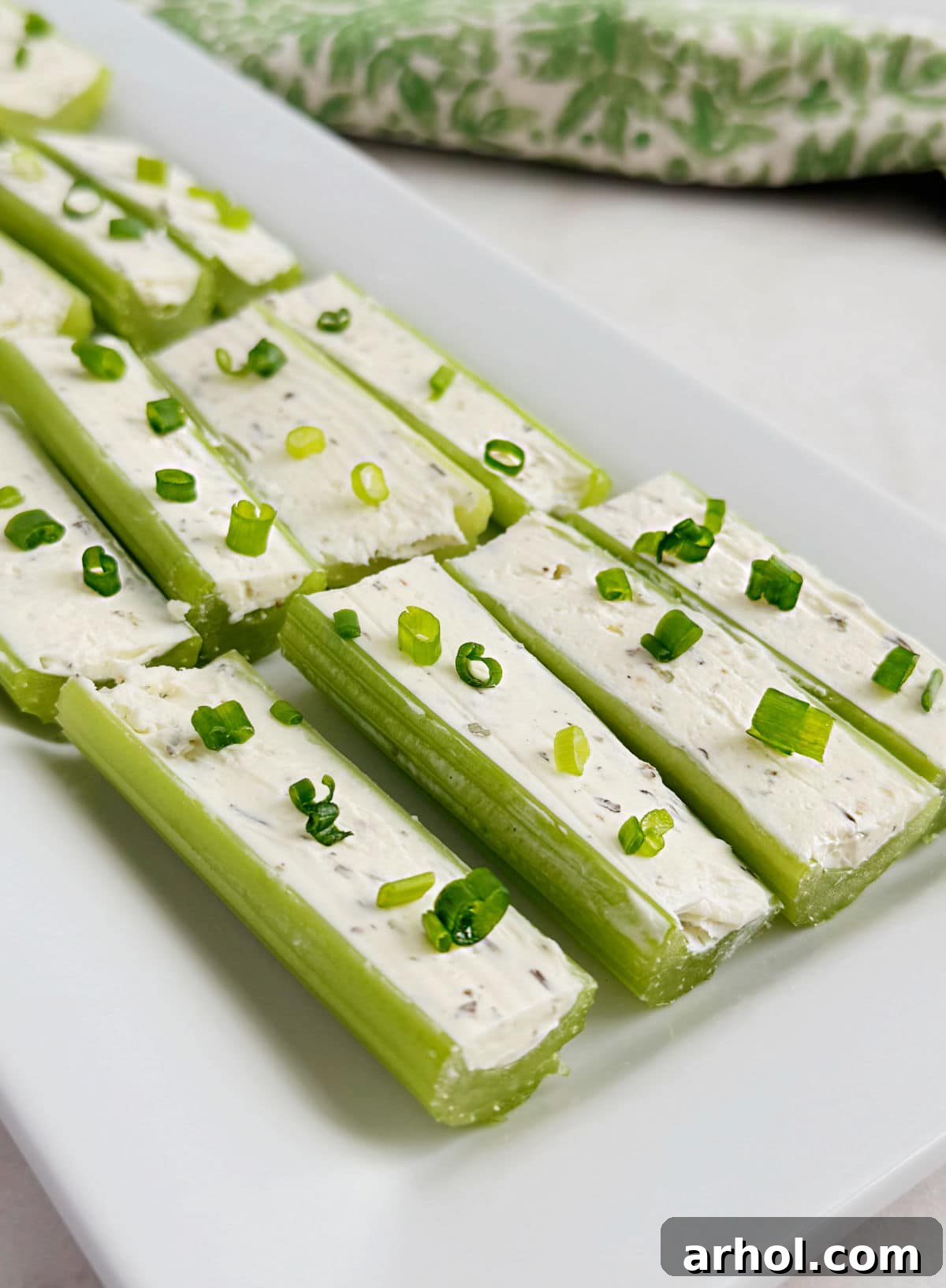 A vibrant platter of cream cheese stuffed celery topped with fresh chives, arranged artfully on a serving tray for an elegant presentation.