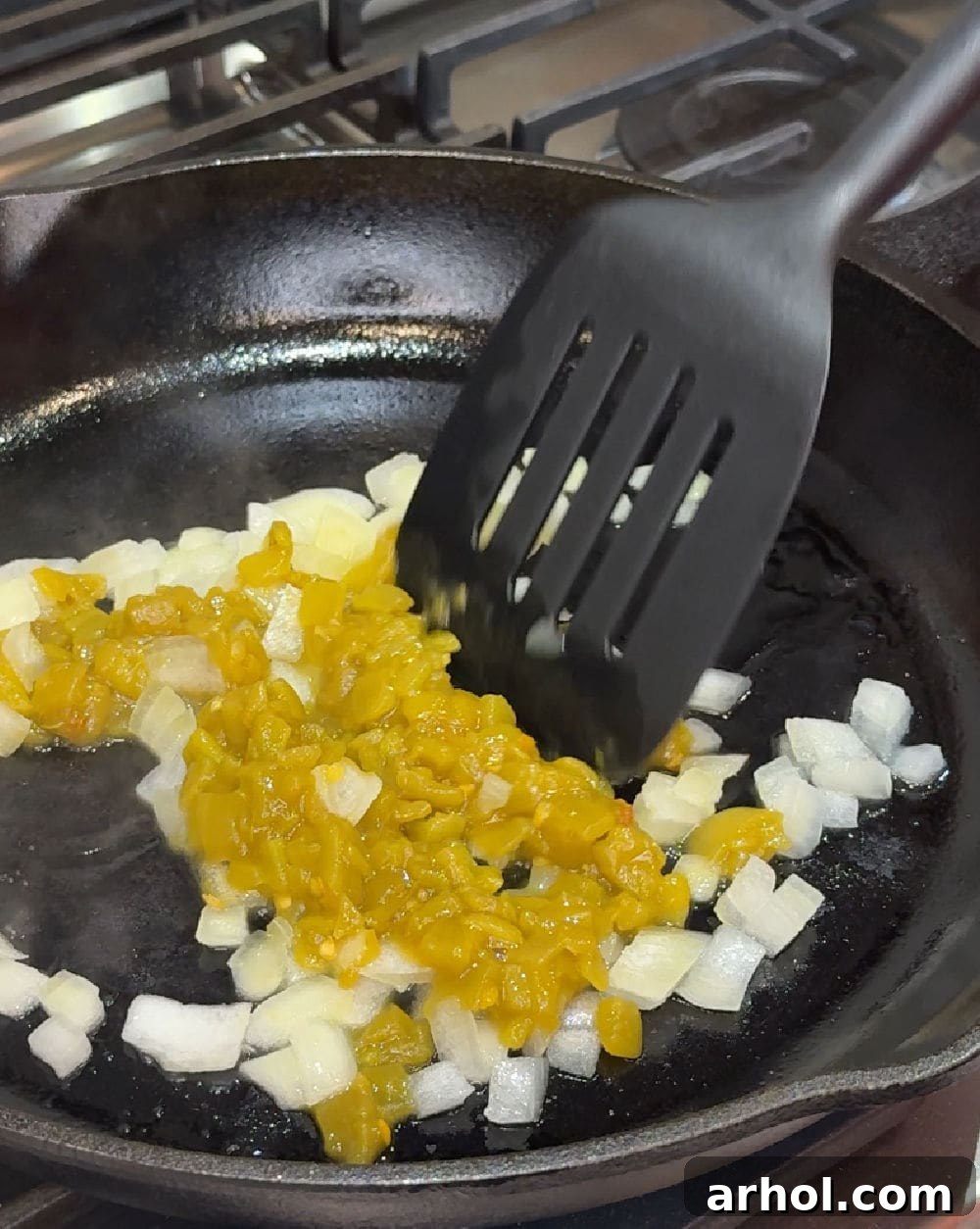 Sautéing onions and green chiles in a skillet.