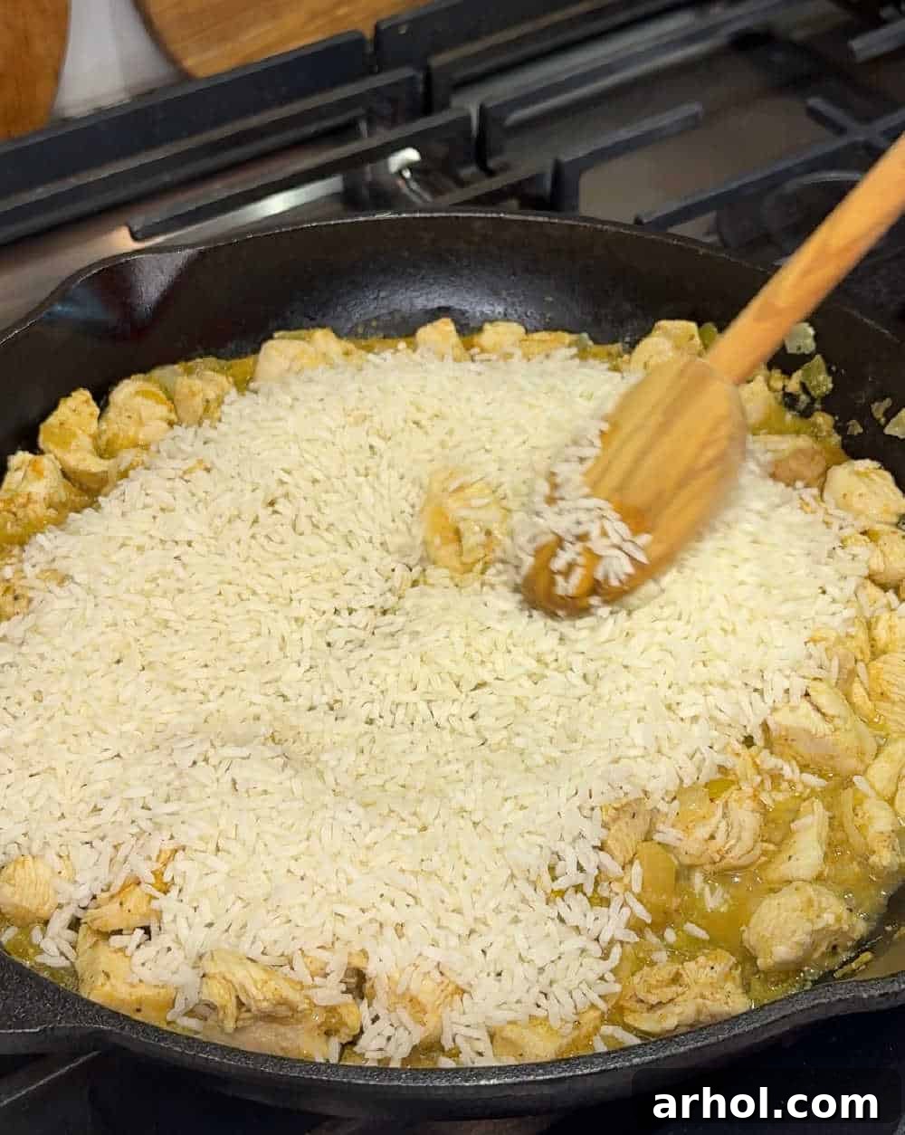 Stirring instant rice into the chicken and vegetable mixture.