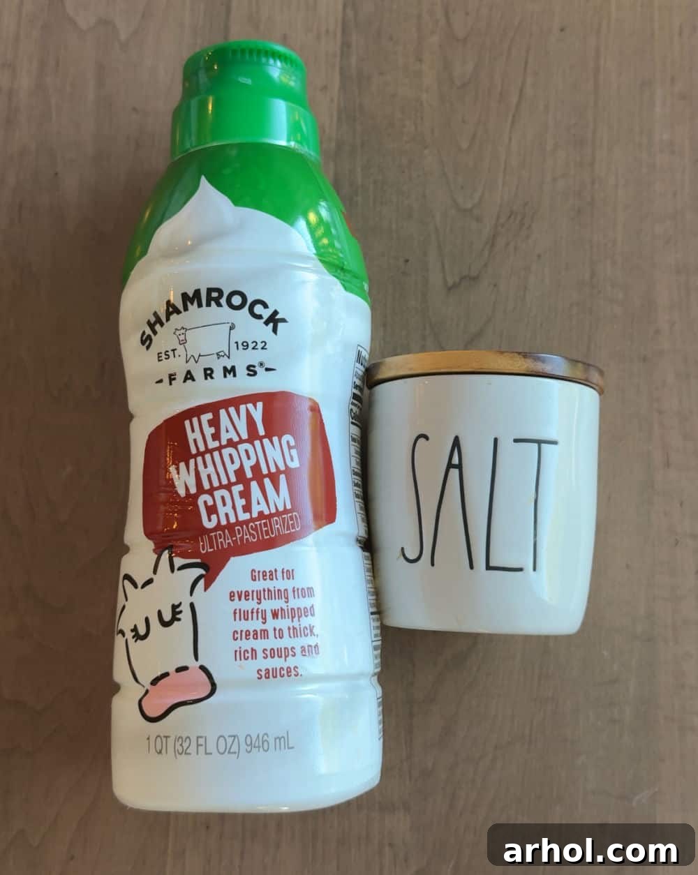 A container of heavy whipping cream and a small bowl of sea salt, the two essential ingredients for making homemade butter.