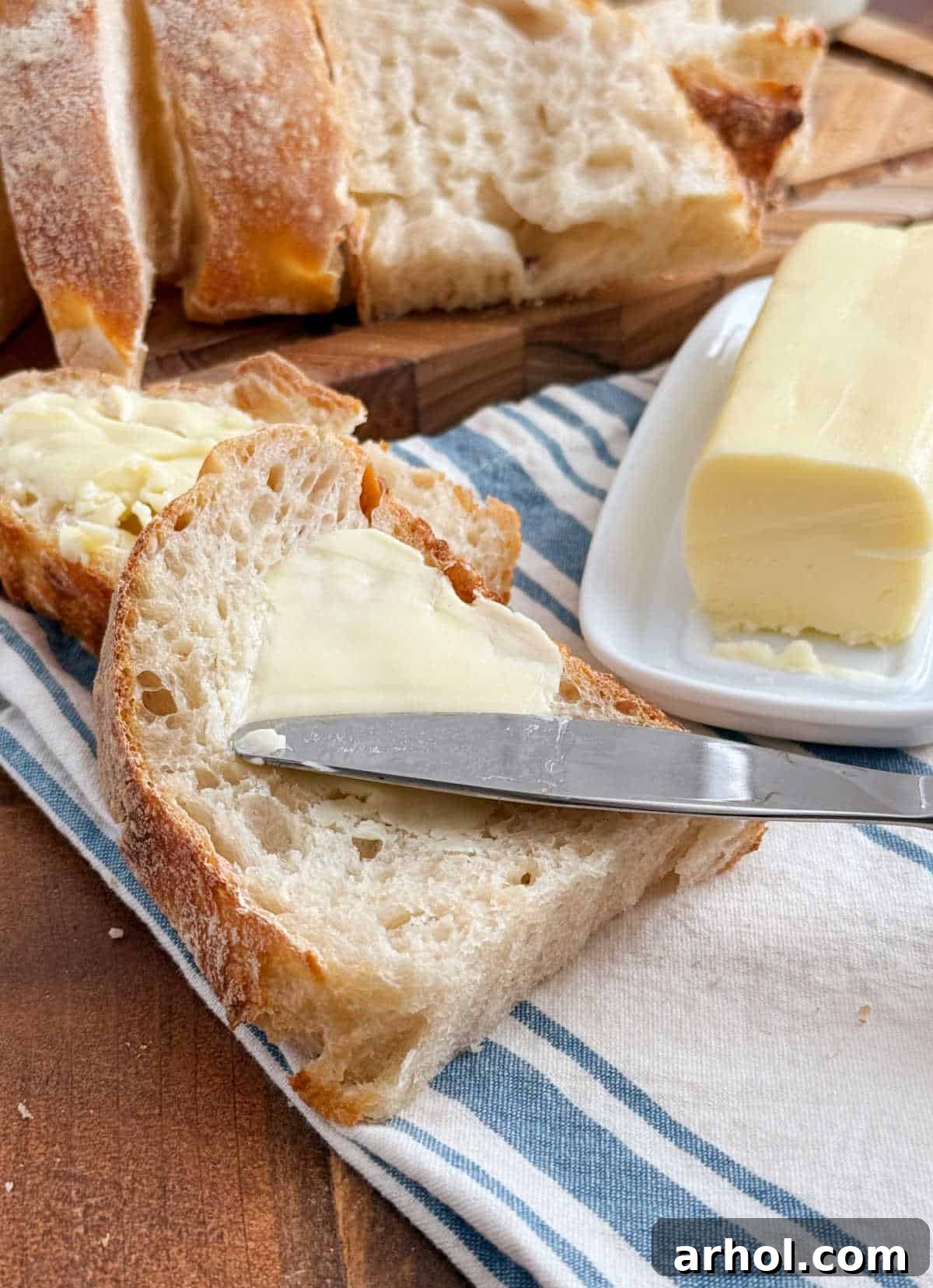Fresh homemade butter spread on a slice of homemade sourdough bread, highlighting its creamy texture.