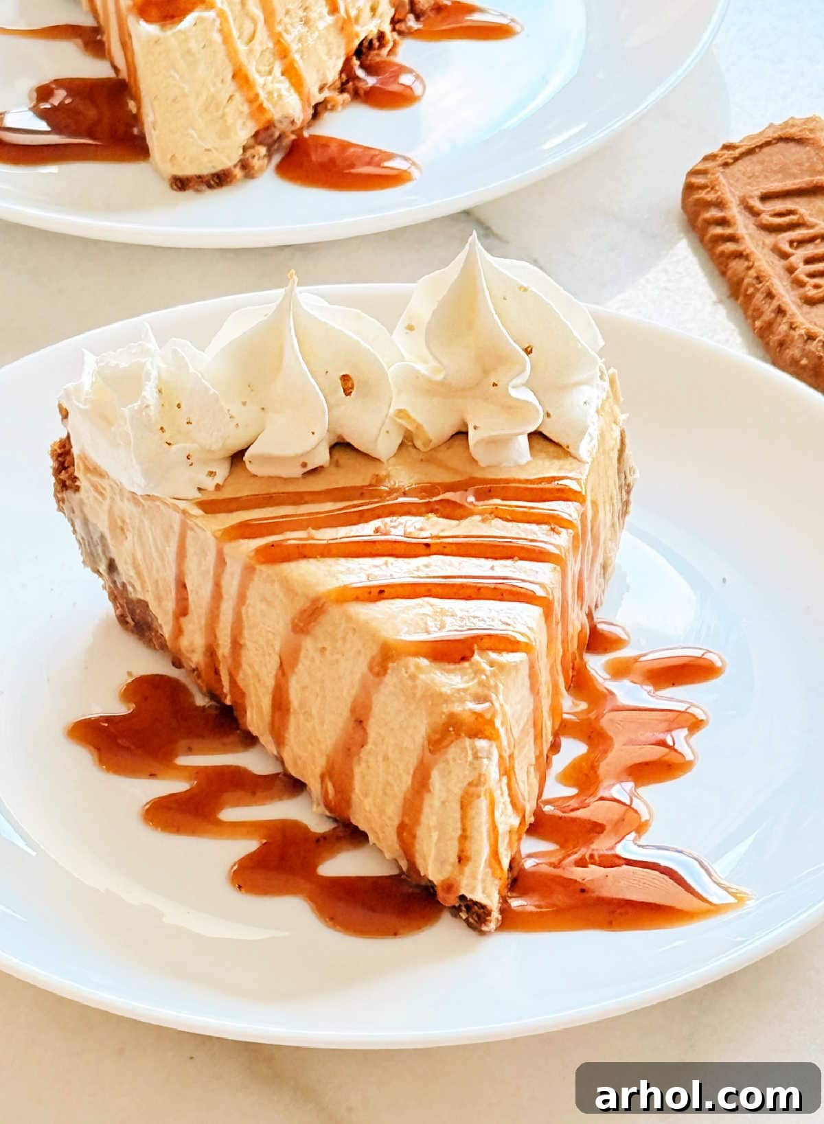 Irresistible No-Bake Cookie Butter Pie 2 cookie butter pie slice with caramel sauce and whipped cream.