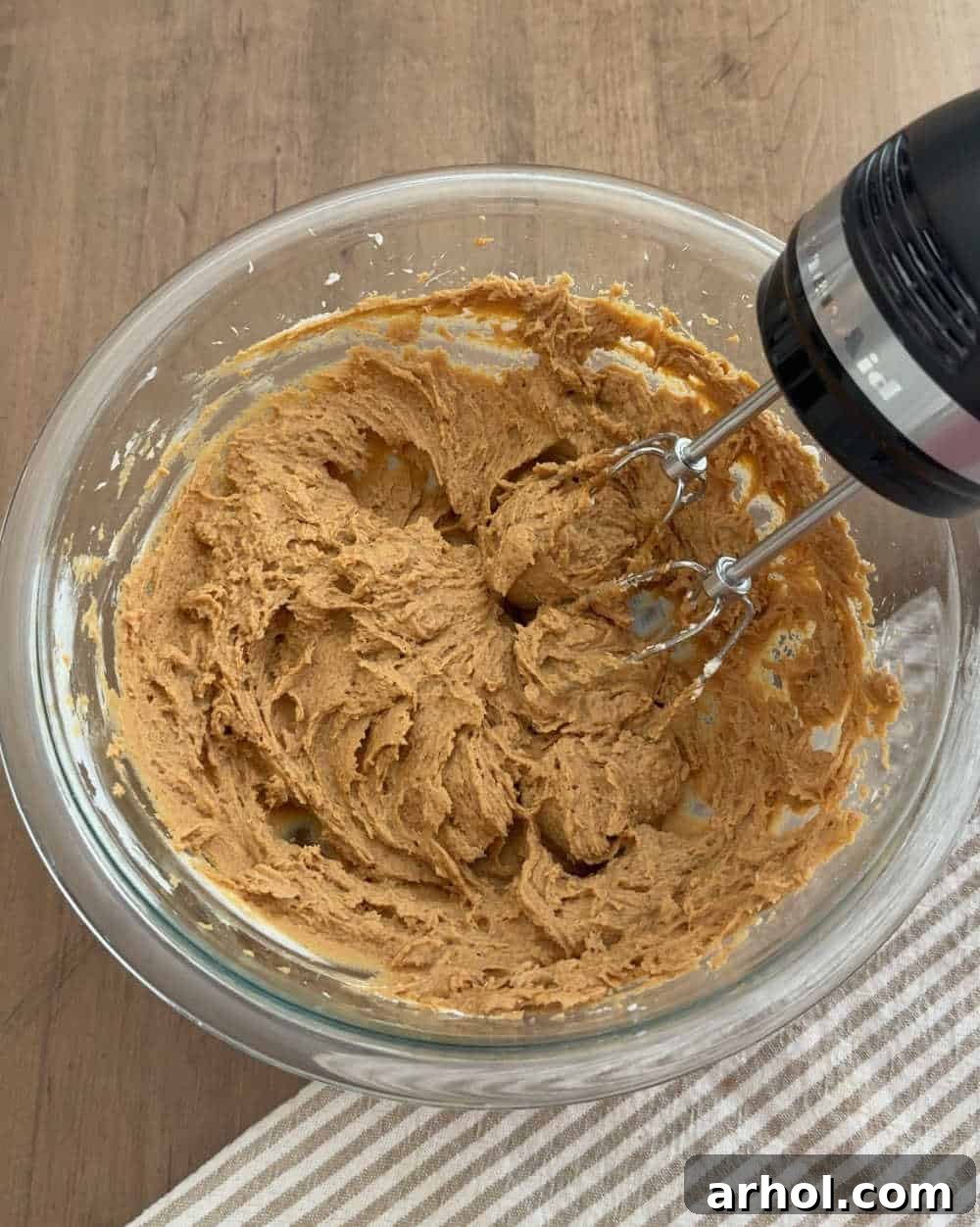 Irresistible No-Bake Cookie Butter Pie 5 mix filling ingredients in bowl with electric mixer.