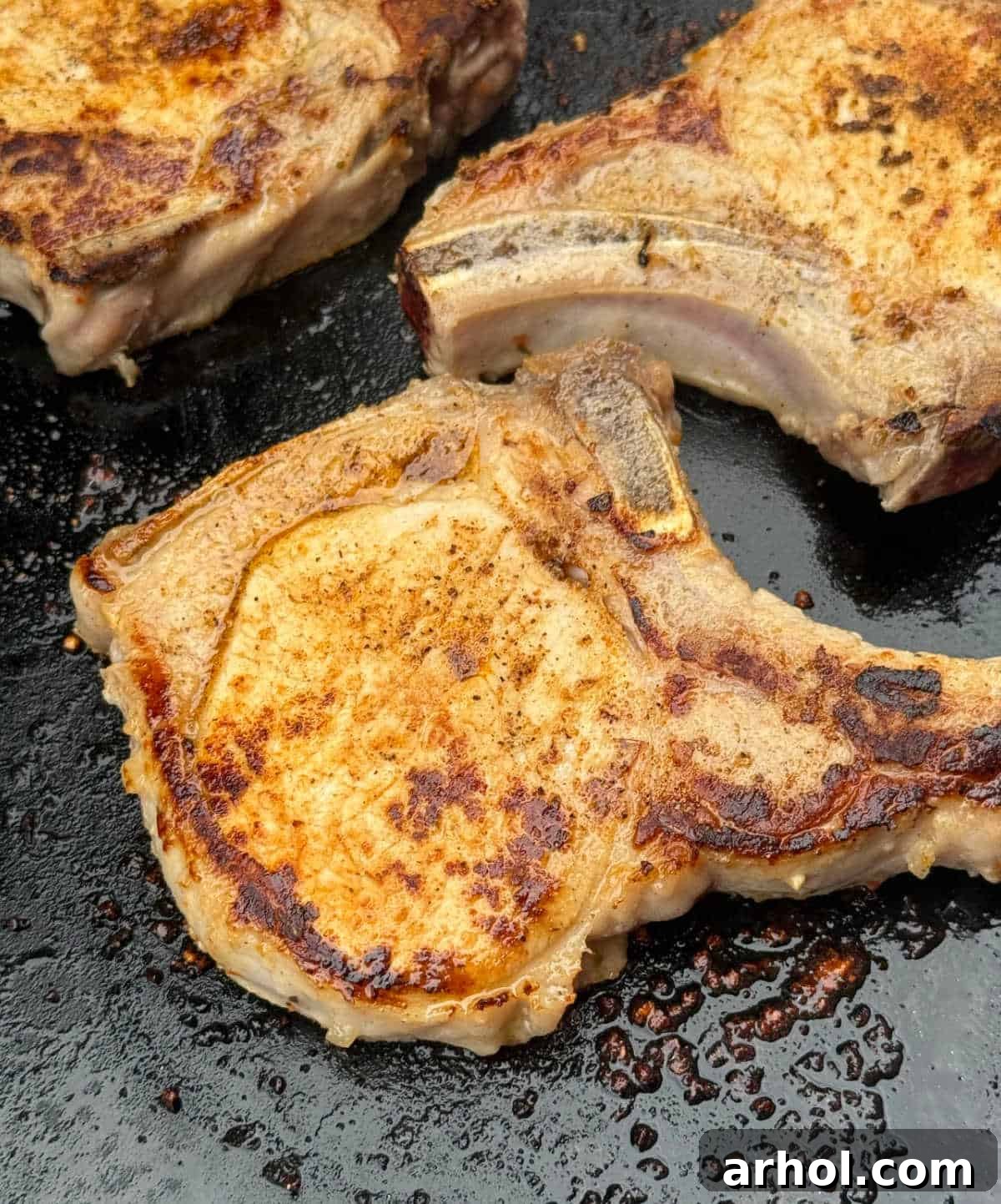 Cooked pork chop on Blackstone griddle, perfectly seared.