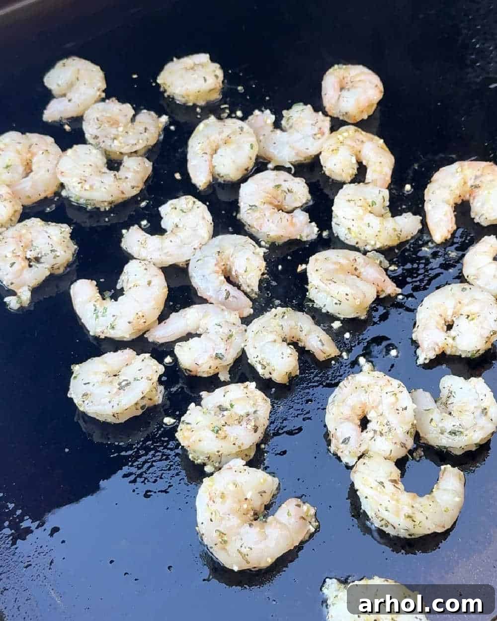 seasoned raw shrimp on griddle.
