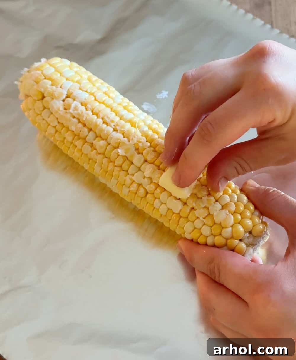 spreading corn cob with butter.
