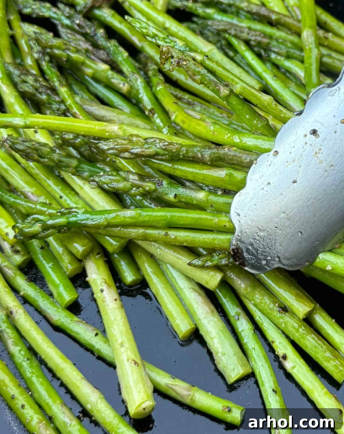 grilled asparagus in tongs.