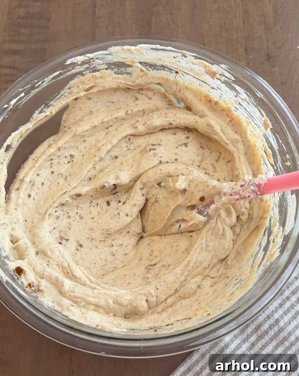 Spatula gently folding the cookie butter mixture into the whipped cream.