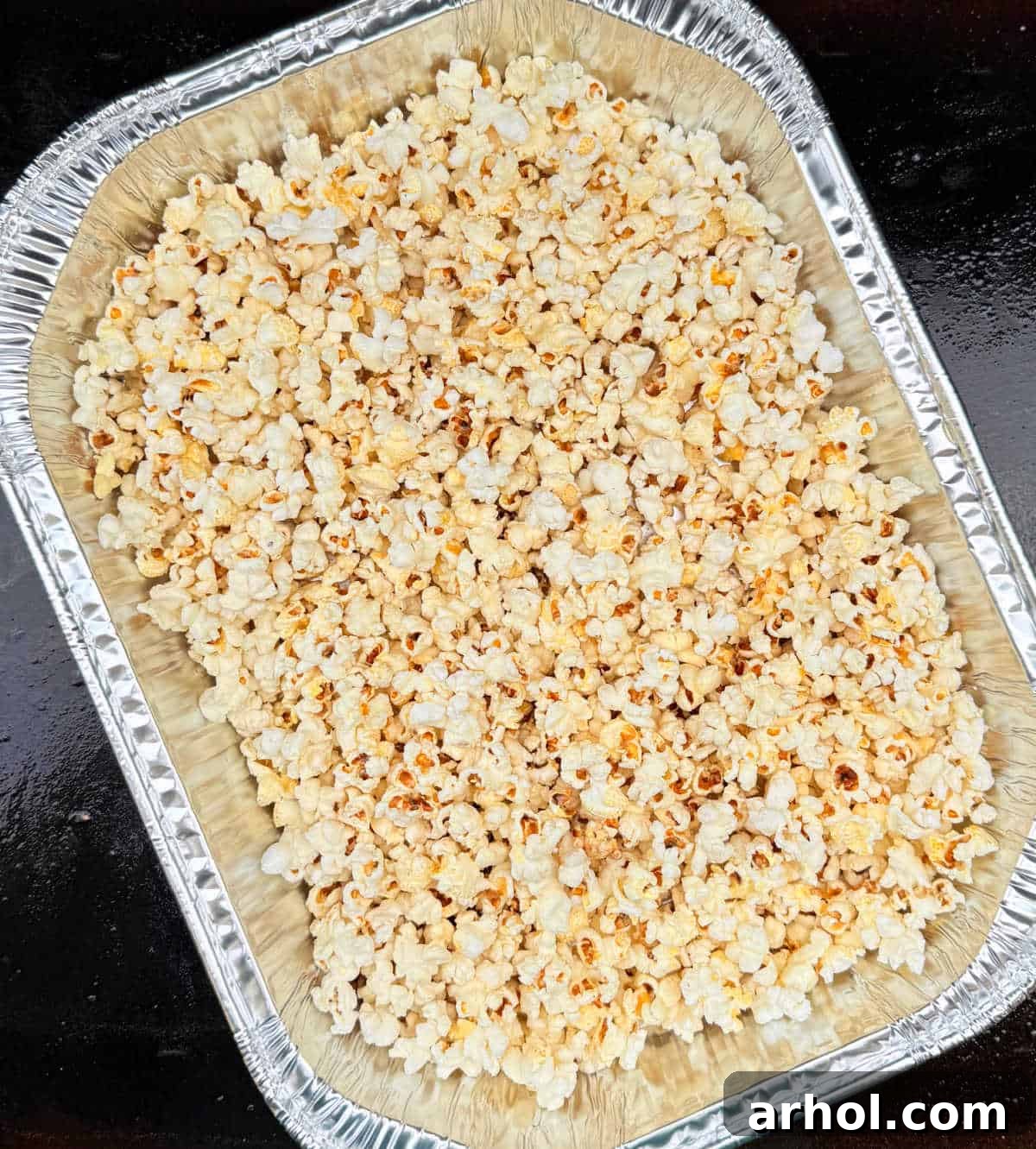 Blackstone popcorn in foil pan on griddle.