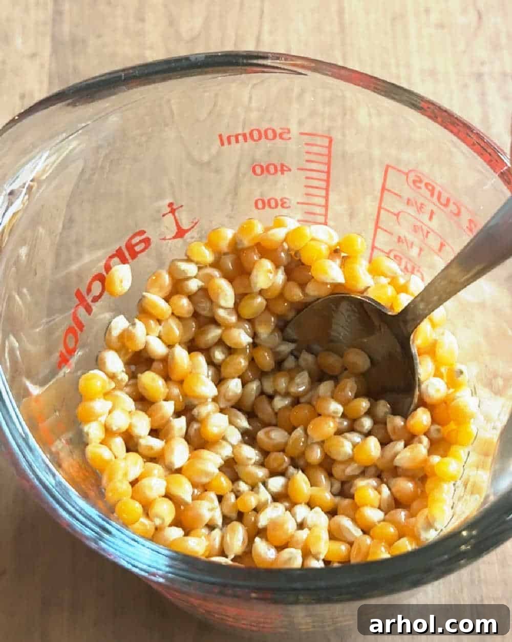 stirring corn kernels in measuring cup.