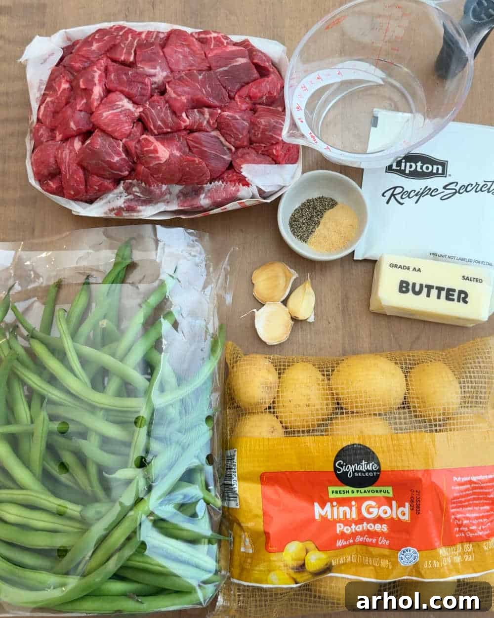 Key ingredients for garlic butter beef bites: beef stew meat, baby potatoes, fresh green beans, butter, and seasonings.