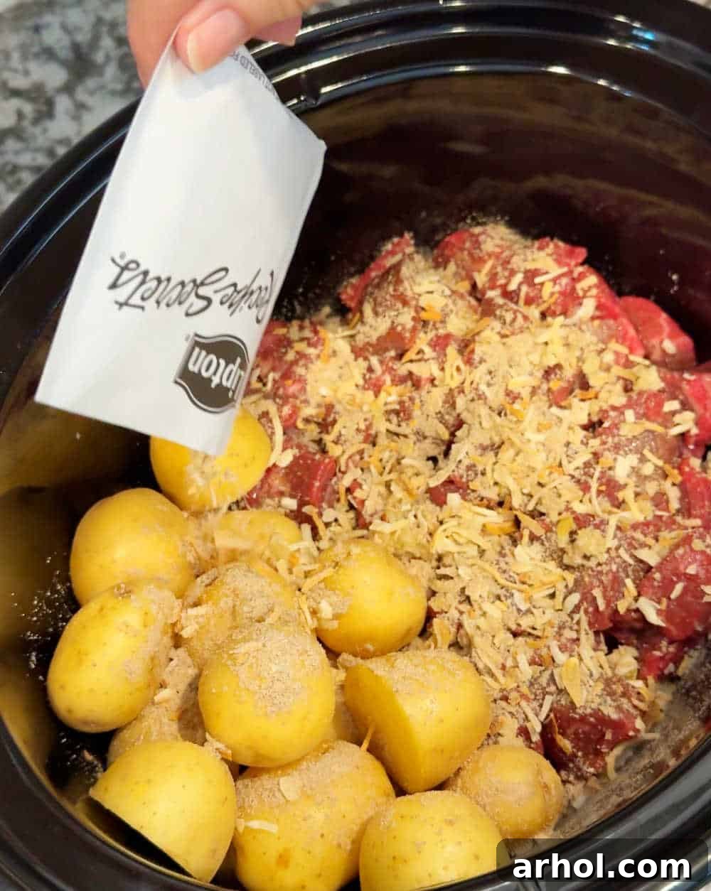 Sprinkle onion soup mix over stew meat and potatoes in the slow cooker.