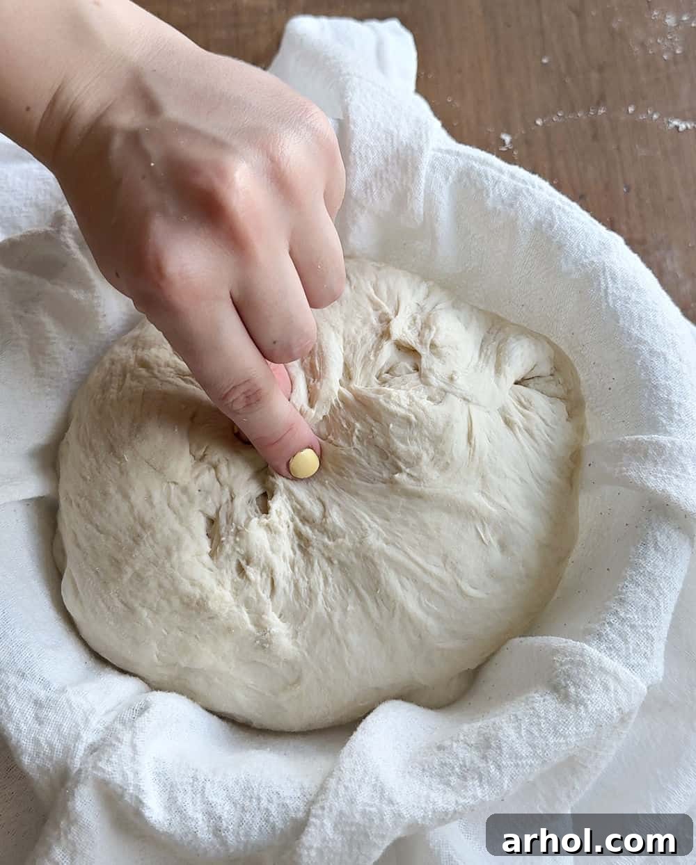 Detail of pinching and stitching the dough together to create crucial surface tension during shaping.