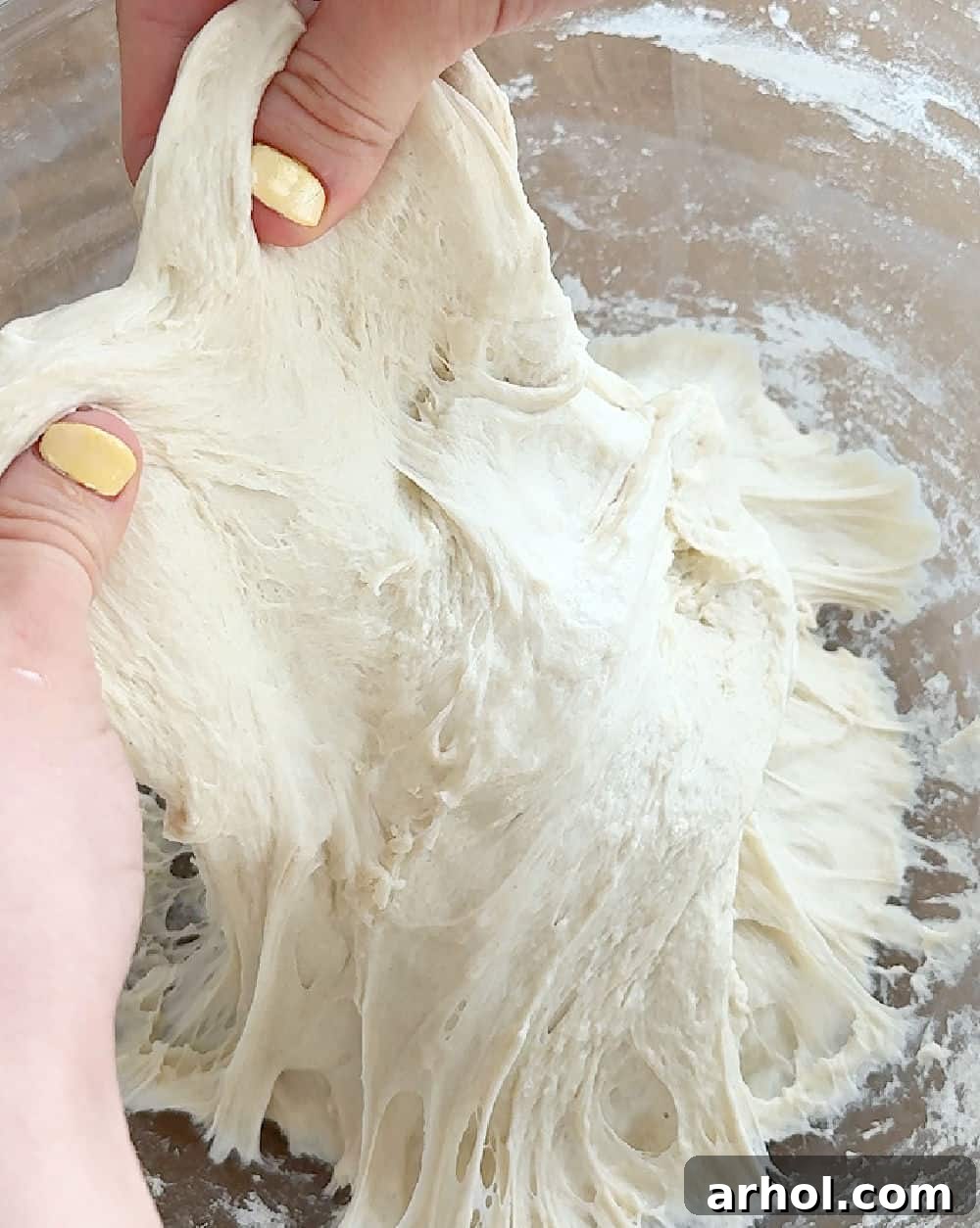 Illustrating the stretching motion of the sourdough dough during the stretch and fold process to develop gluten.