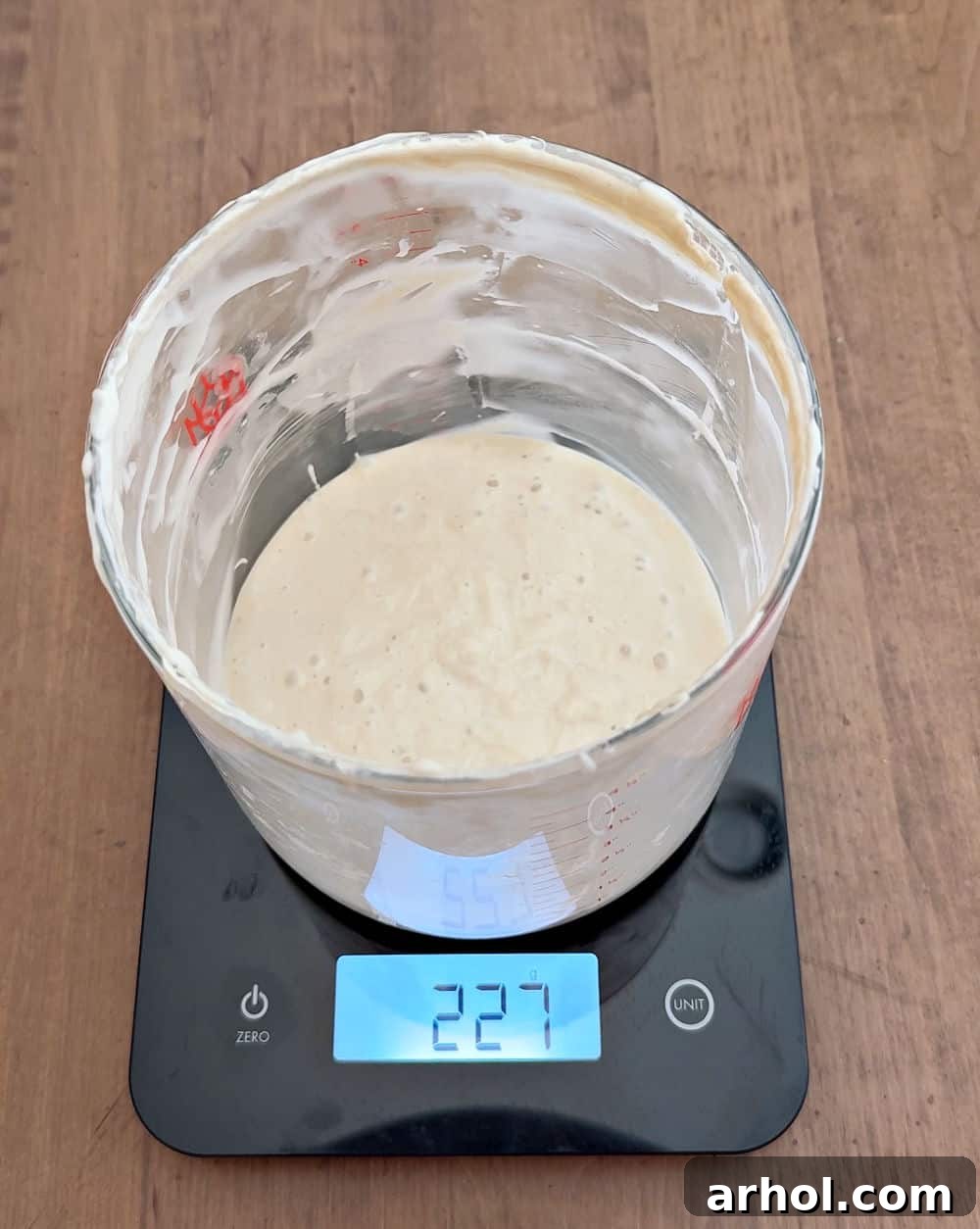 Sourdough starter being weighed on a digital kitchen scale.
