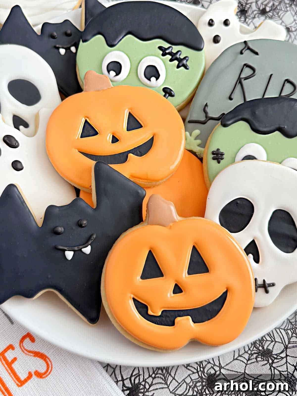 plate of cut-out halloween sugar cookies decorated with royal icing.